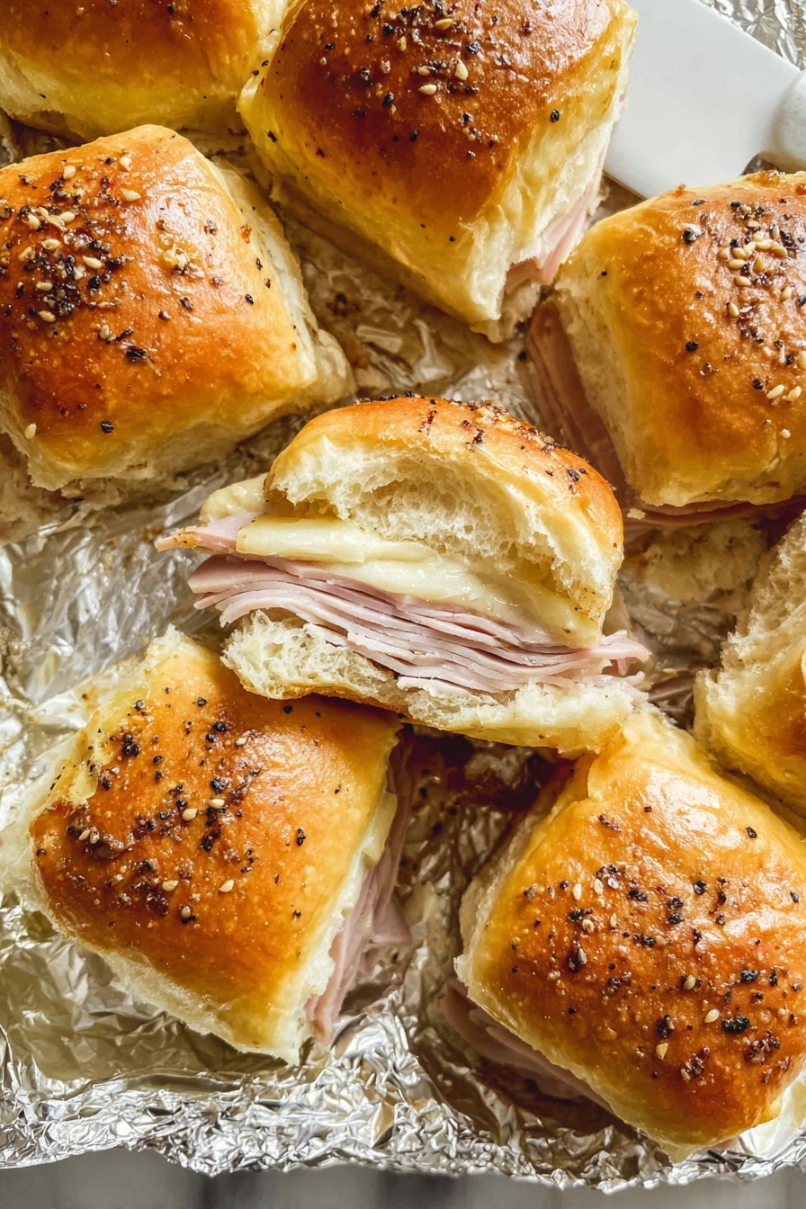 A close-up view of a sandwich held by a woman's hand shows three layers: the top layer is a shiny golden-brown bun topped with a few black sesame seeds; below it is a layer of melted light yellow cheese stretching slightly; under the cheese, there are thin slices of pale pink meat; and the base is a soft, slightly toasted bread roll with a light golden crust. The background features more sandwiches blurred out on a white marbled surface. Photo taken with an iphone --ar 2:3 --v 7