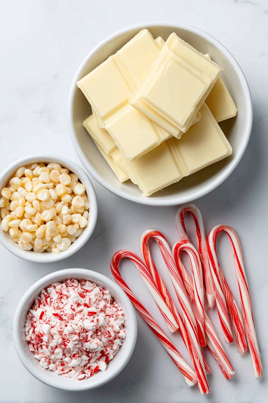 Flat lay of a small pile of pale yellow popcorn kernels, a small white ceramic bowl filled with smooth white chocolate wafers, a small white ceramic bowl holding finely crushed bright red and white candy cane pieces, and four whole fresh candy canes with red and white stripes arranged neatly, all placed on a clean white marble surface, soft natural light, photo taken with an iPhone, professional food photography style, fresh ingredients, white ceramic bowls, no bottles, no duplicates, no utensils, no packaging --ar 2:3 --v 7 --p m7354615311229779997