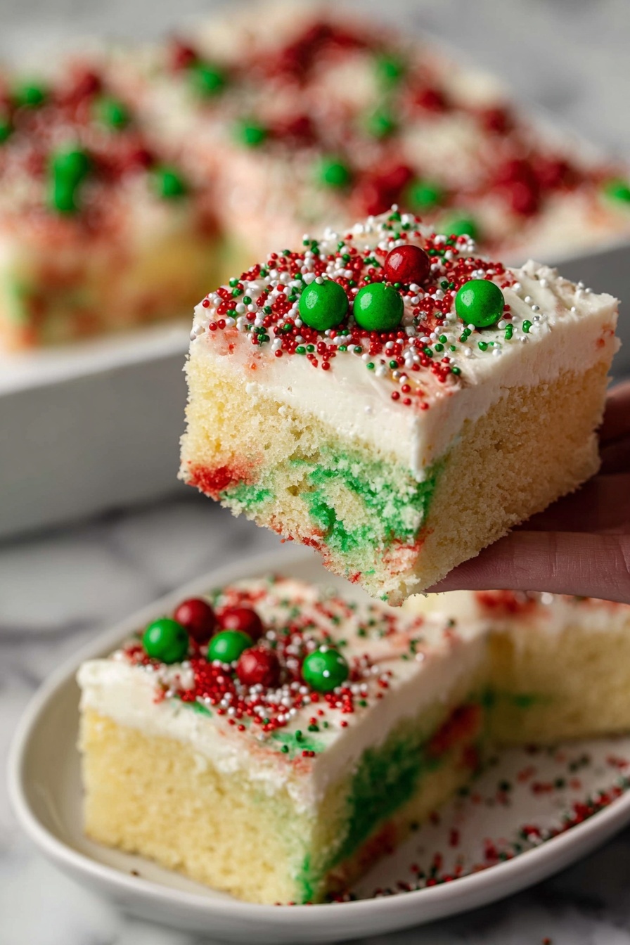 The image shows a single square slice of a colorful cake on a white plate with a red and white cloth underneath. The cake has two main layers: the bottom layer is a light sponge with bright green and red spots that look soaked with syrup, creating a wet texture with small holes. On top, there is a thick layer of smooth white frosting decorated with small round green and red sprinkles scattered evenly. The cake looks moist and soft, and the background is a white marbled texture with blurred shapes giving it depth. Photo taken with an iphone --ar 2:3 --v 7