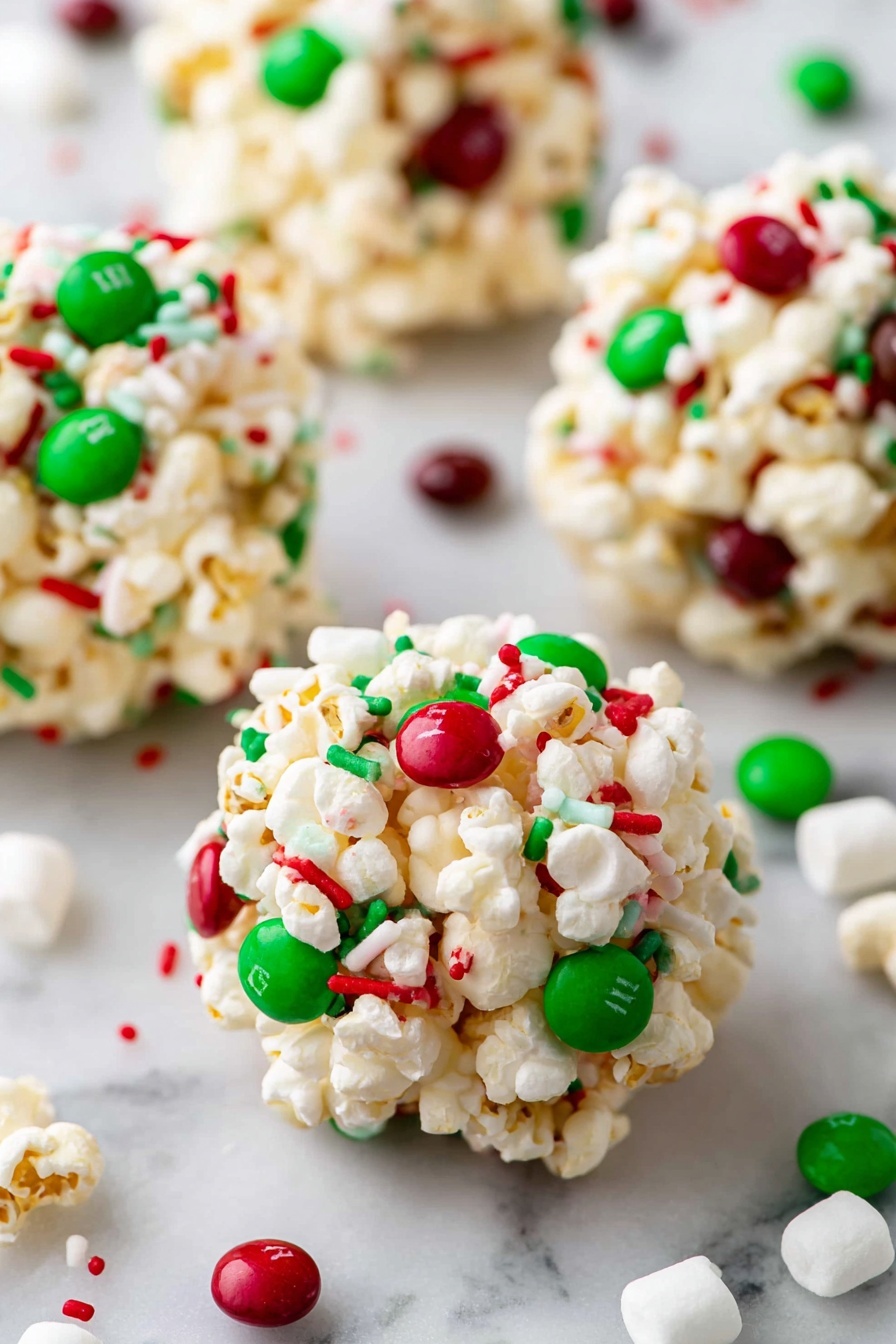 There is a wooden plate filled with round popcorn balls, each made of light-colored popcorn mixed tightly with small red and green candy pieces and sprinkles, giving them a festive look. The popcorn balls are placed close together, showing their bumpy texture with the colorful candies spread evenly on each one. The plate sits on a white marbled surface with holiday decorations nearby, including red and black checkered cloth, pine cones, a white wooden stand with red snowflake designs, and a few green Christmas ornaments scattered around. photo taken with an iphone --ar 2:3 --v 7